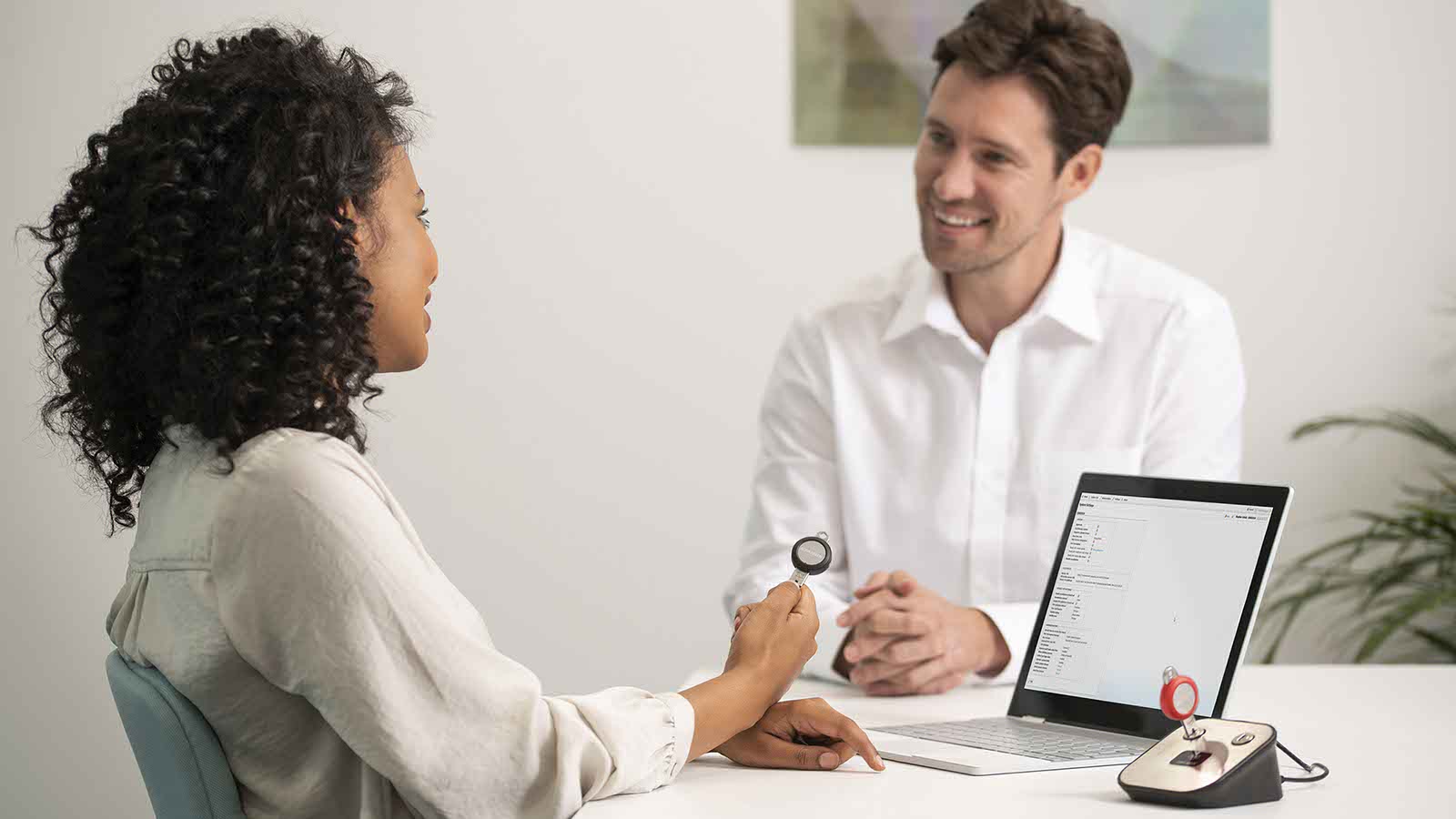 Man and Woman Sat Across A Table With Laptop On The Table