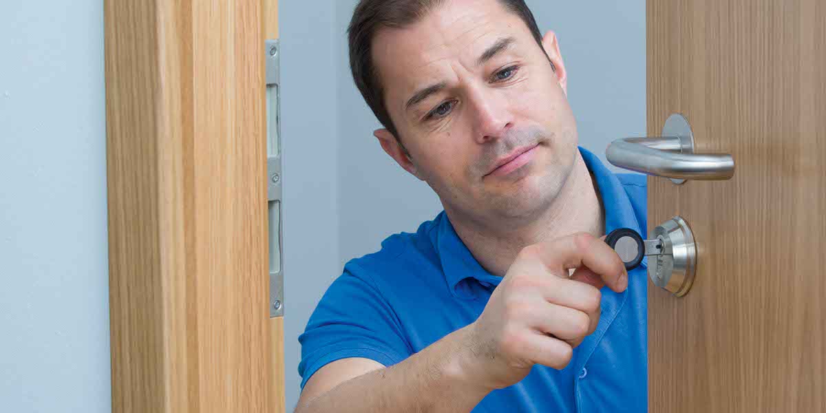 Man In A Blue Shirt with A Key In Door